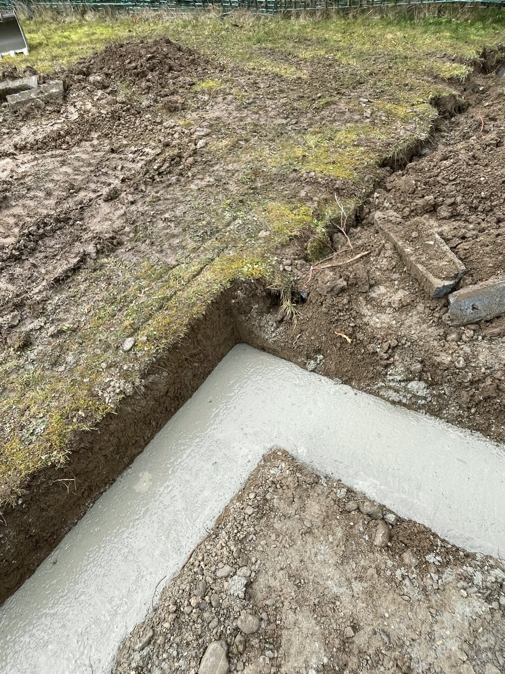 Semelle de fondation béton coulée en angle sur un chantier de maçonnerie