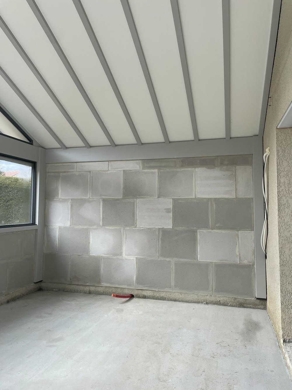 Mur intérieur monté en parpaing sous une charpente