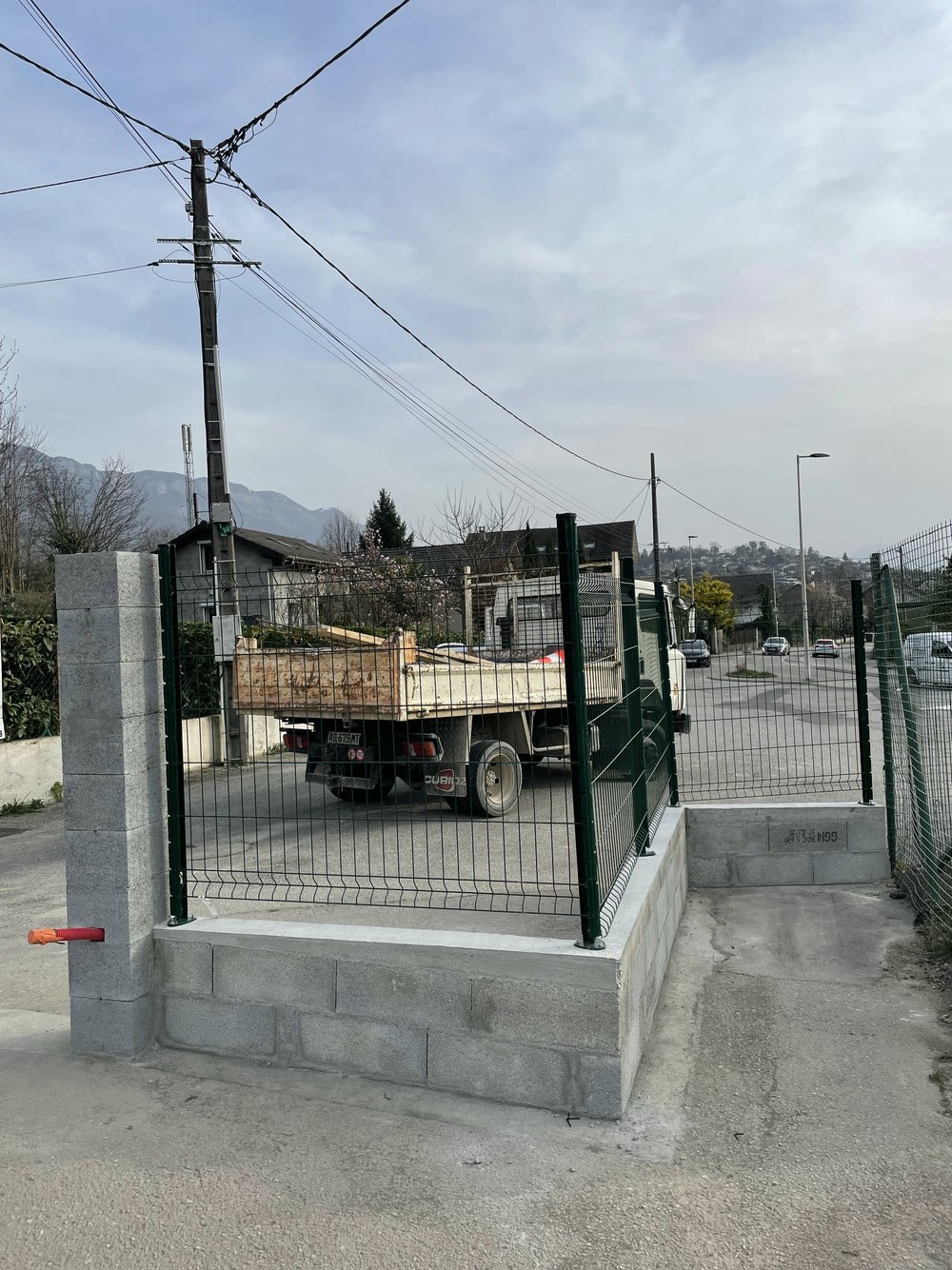 Muret en parpaing supportant une clôture rigide, chantier près d'Annecy