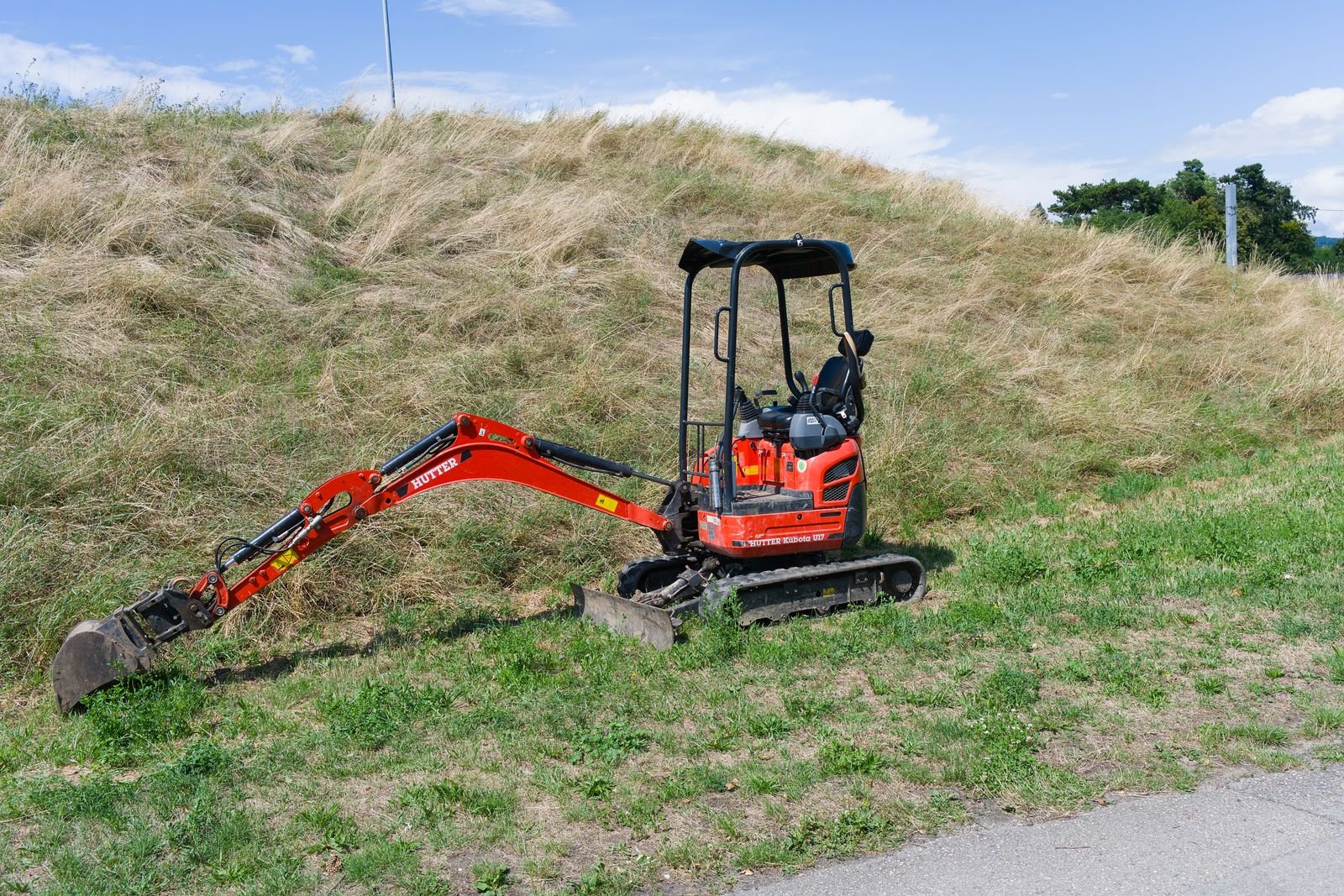 Mini-pelle de l'entreprise posée sur un terrain en pente